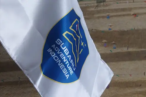 Bendera custom berwarna putih dengan logo Subaru Adventure Indonesia berwarna biru, hasil cetak logo tajam dan finishing rapi.